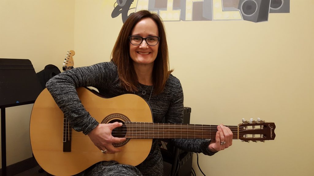 Elise playing an acoustic guitar
