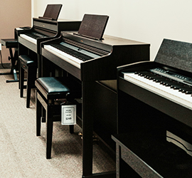 Pianos lined up along a wall