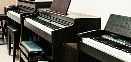 Pianos lined up against a wall