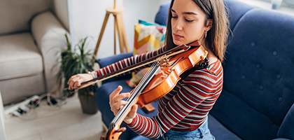 A woman playing violin at home