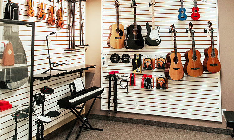 Guitars, violins, drums, and a piano up against the wall