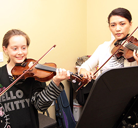 Two girls playing violin